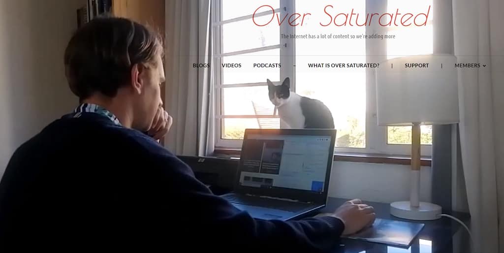 Image for the First YouTube Video on the Over Saturated channel - Tyrone working with a cat in front of his laptop