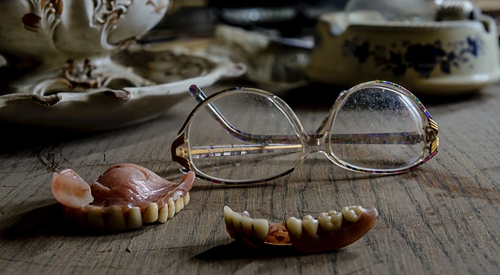 Dentures lying next to glasses