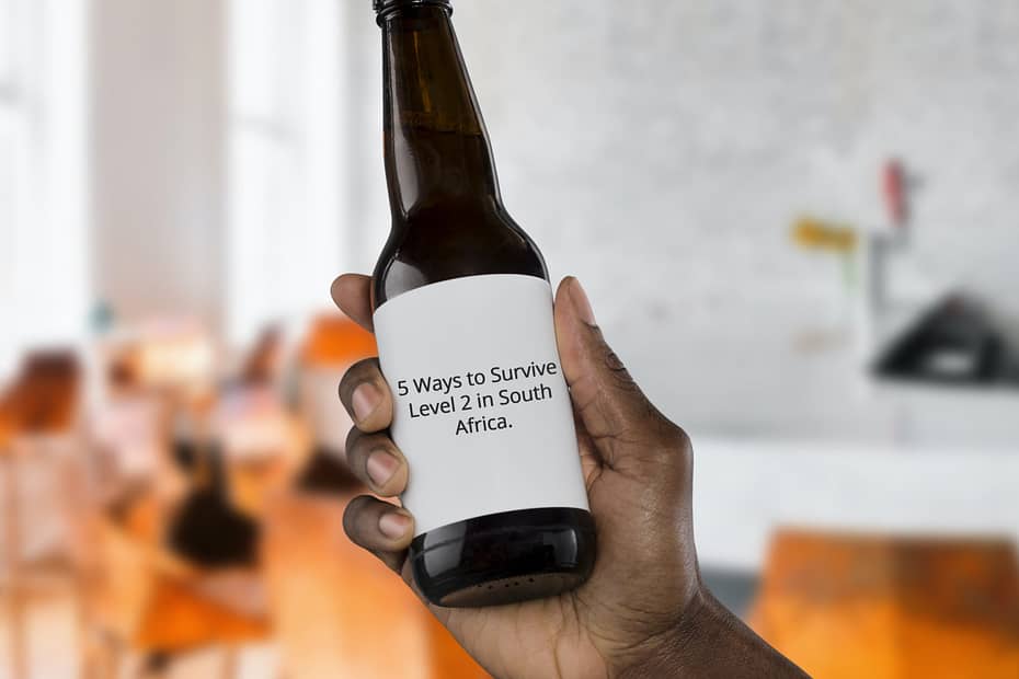 Beer bottle being held with 5 ways to survive level 2 in South Africa written on it